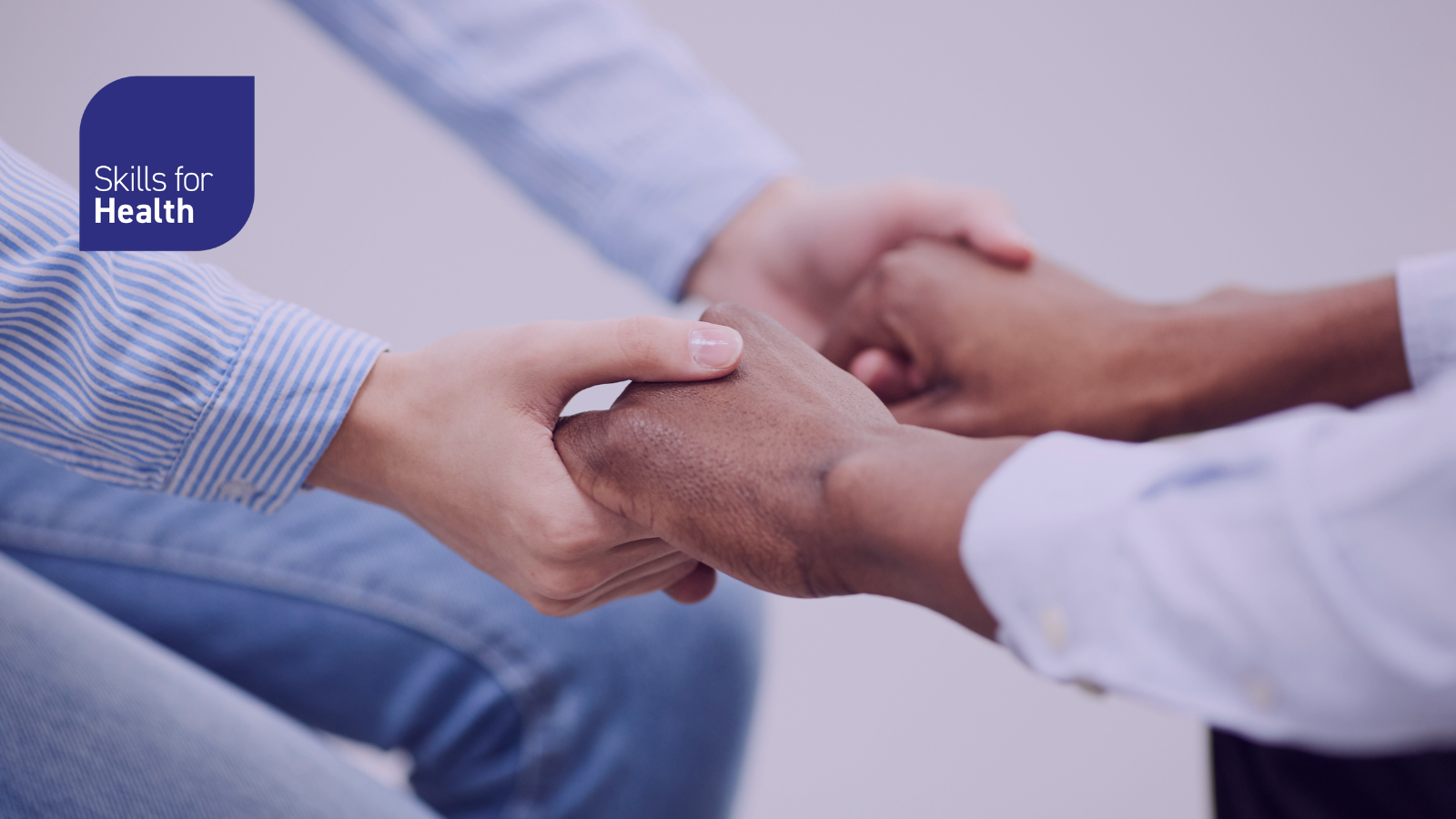 Two people holding hands in a supportive way