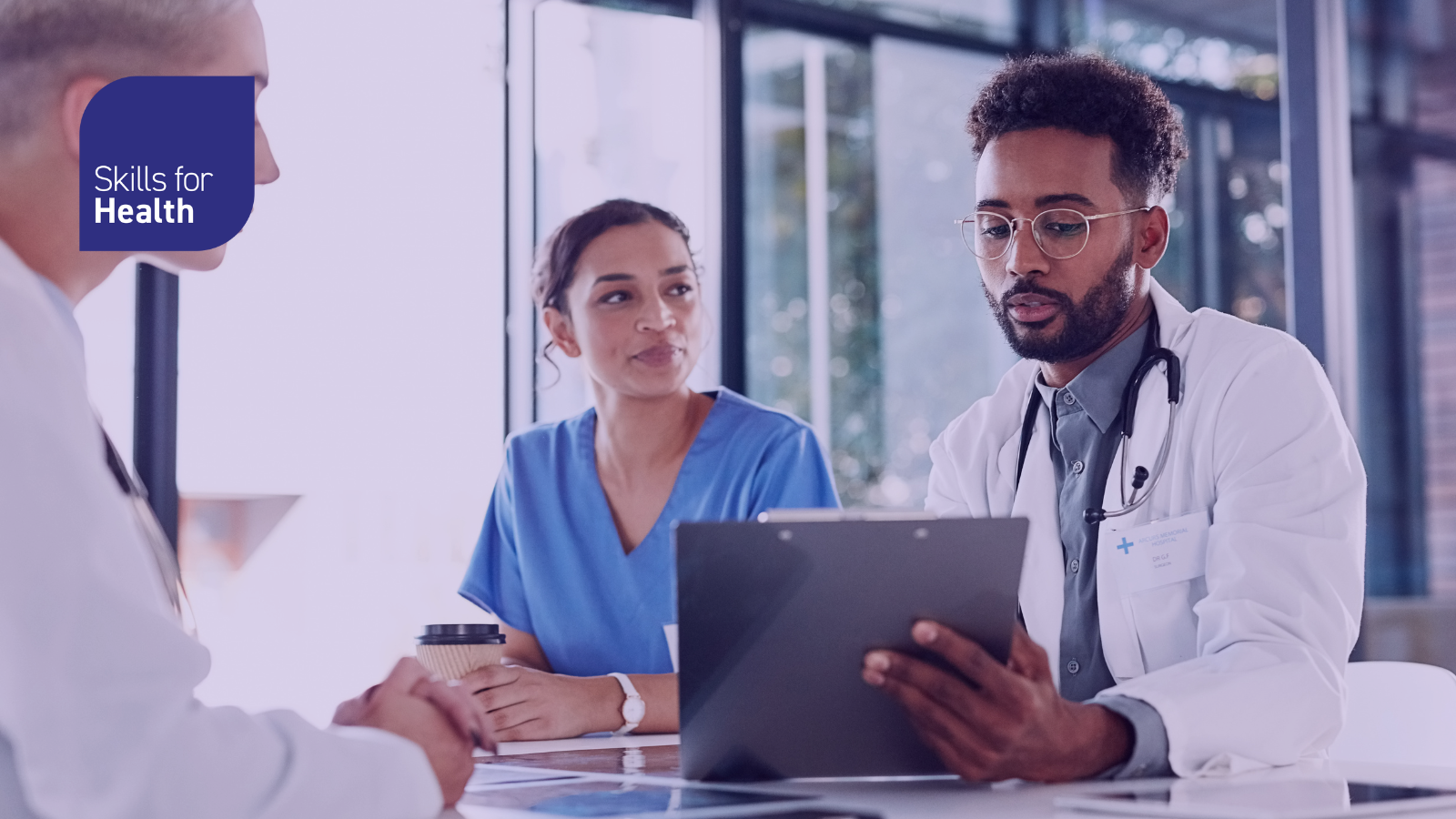 Hospital staff looking at a clipboard around a table